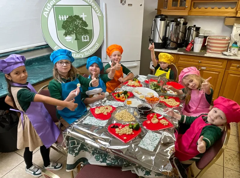 Children in chef costumes during cooking day at Alderwood Academy