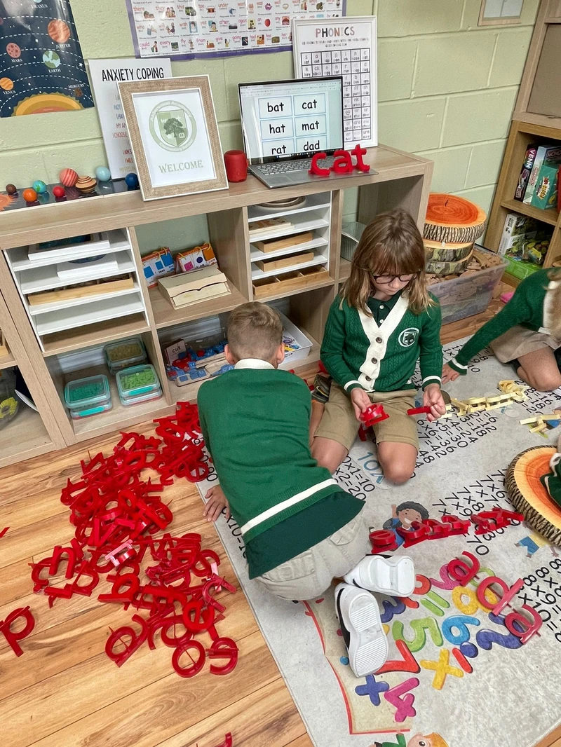Kindergarten students engaged in phonics letter play activities demonstrating progressive learning framework at Alderwood Academy